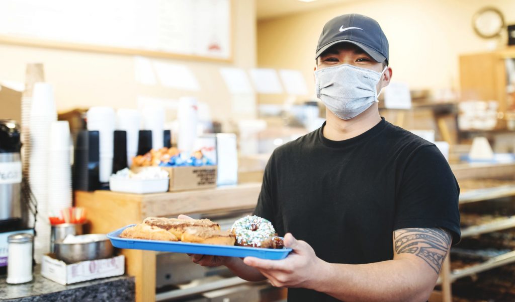 Chuck’s Donuts in Renton, WA Man holding donuts at Chuck's Donuts in Renton, Washington.